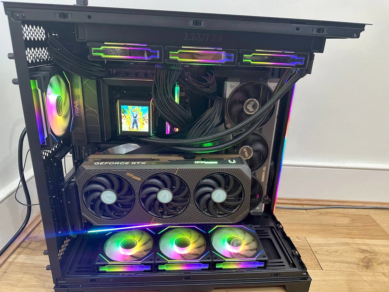 The machine running with the side and front glass panels removed, both graphics cards and the AIO pump screen visible